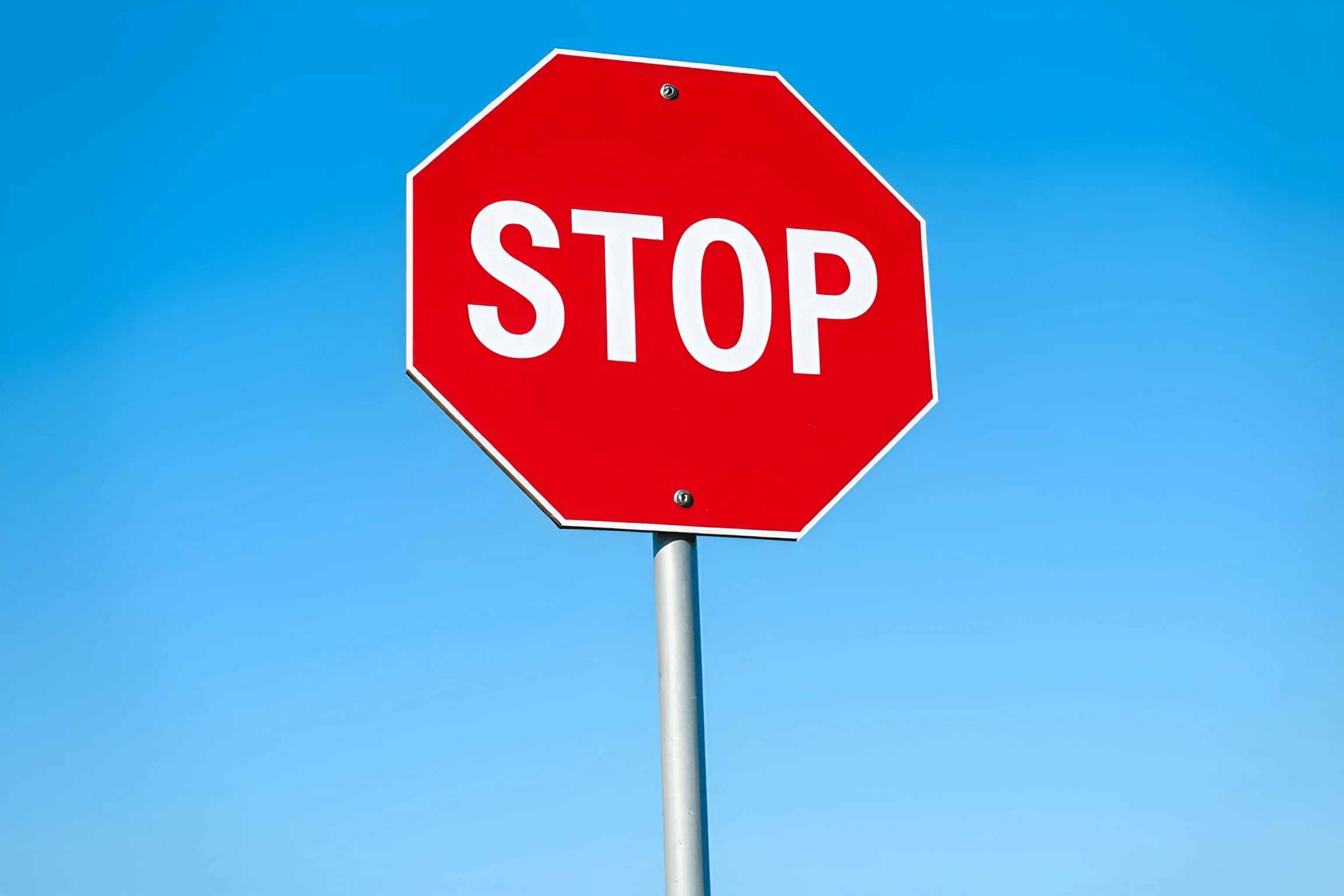 Red Octagonal Stop Sign Against Blue Sky - Free Download - AI Scribbles