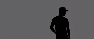Artistic monochromatic silhouette of a man wearing a hat, standing against a plain gray background. This minimalist style artwork captures simplicity and intrigue through the use of shadows and light.